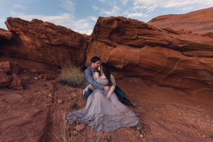 couple kissing under red rock outcropping in valley of fire nevada during their adventure session