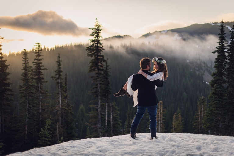 adventure elopement photography, elopement, olympic national park elopement, fog, sunset, snow, adventurous couple, flower crown, lace wedding dress, mountain top, snow, navy blue suit jacket, blue jeans