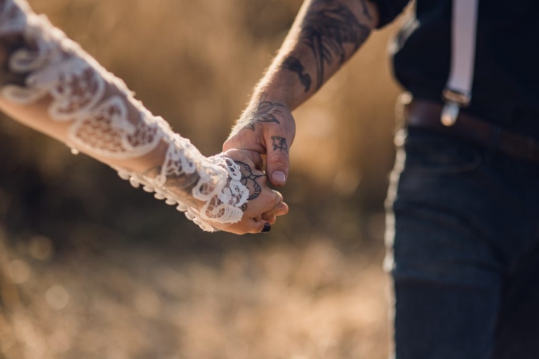 bride leading groom through golden field for elopement