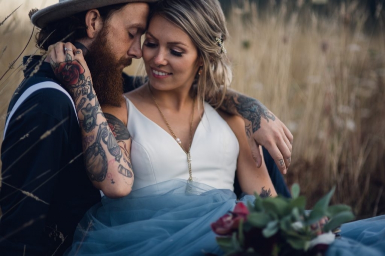 adventurous couple sitting in wheat field during elopement