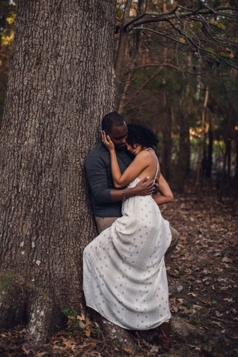couple leaning against tree during adventure session in virginia