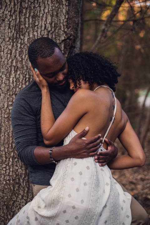 couple leaning against tree during adventure session in virginia