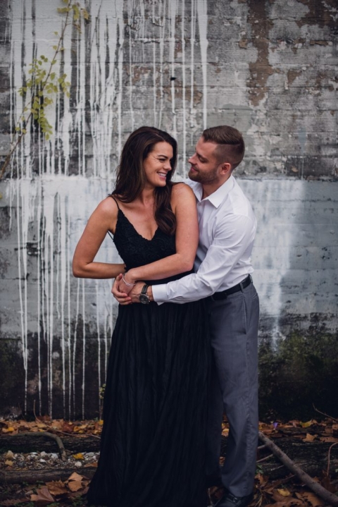engagement couple standing in front of painted wall