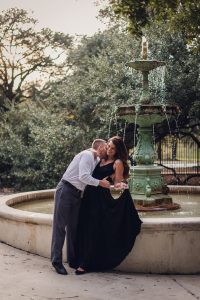engaged couple in front of green fountain