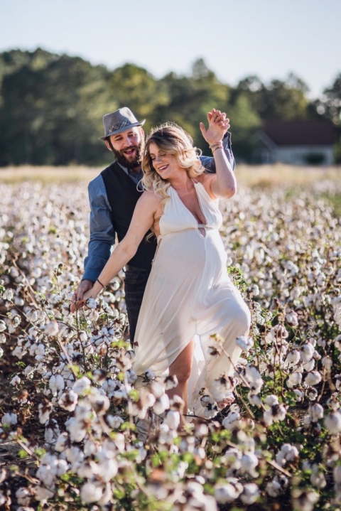 adventurous couple walking in cotton field