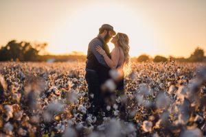 backlit couple during sunset in a cotton field