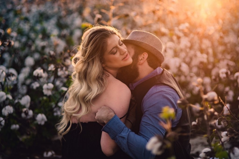 passionate couple in a cotton field during sunset