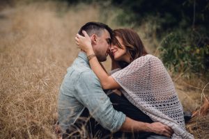 adventurous couple face to face in tall yellow grass