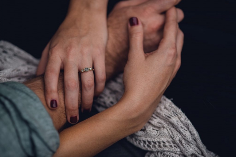 engagement ring on intertwined hands