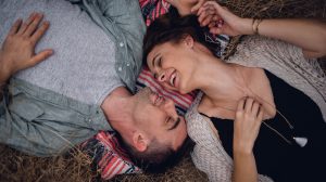 adventurous couple laying on blanket laughing