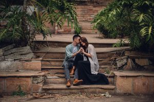 adventurous couple sitting in overgrown ruins
