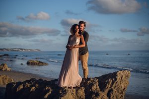 adventurous couple snuggling on a beach