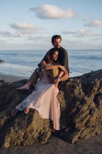 adventurous couple snuggling on a beach