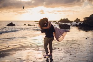 adventurous couple twirling on a beach