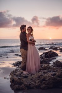 adventurous couple embracing at sunset on the beach