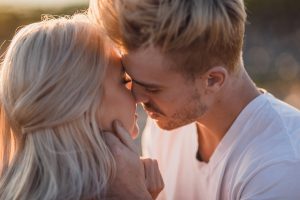 adventurous couple kissing at sunrise
