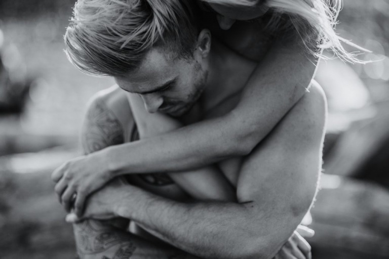 adventurous couple embracing during ruby beach engagement session