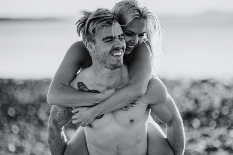 adventurous couple piggy back ride on ruby beach
