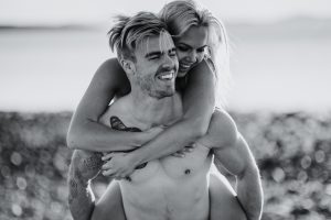 adventurous couple piggy back ride on ruby beach