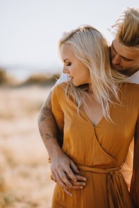 adventurous couple embracing in golden grass