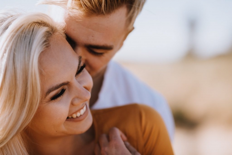 adventurous couple embracing in golden grass