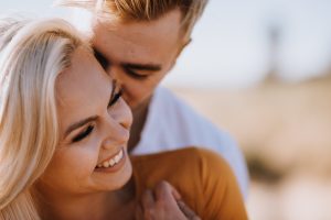 adventurous couple embracing in golden grass