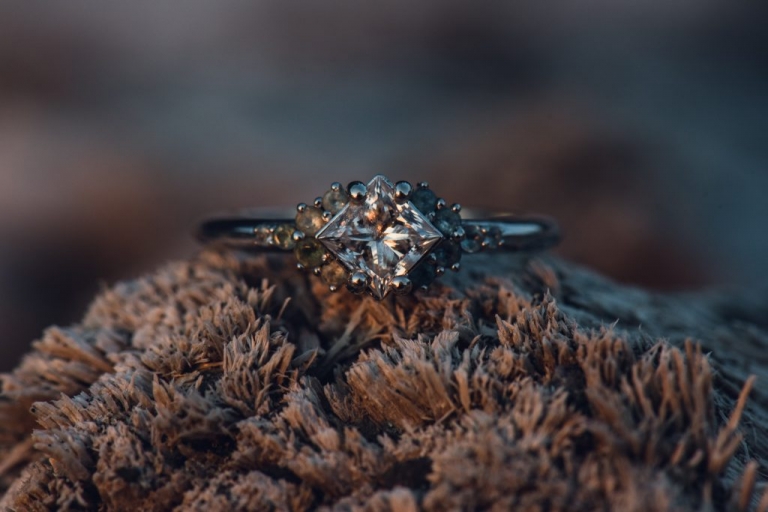 diamond engagement ring on driftwood at ruby beach