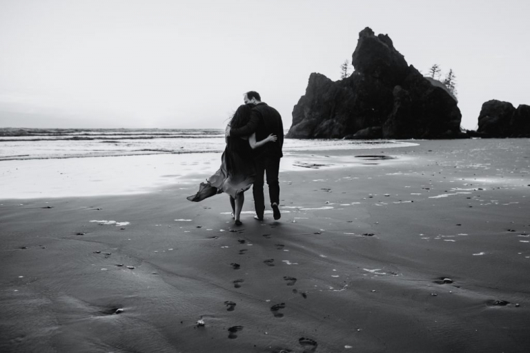 adventurous couple walking on ruby beach during olympic national park engagement session
