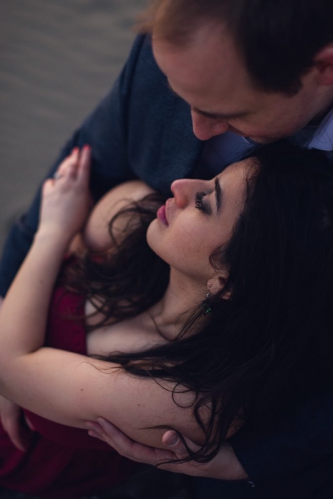 adventurous couple embracing on ruby beach during olympic national park engagement session