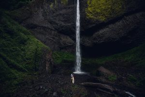elopement couple standing at the base of latourell falls in oregon