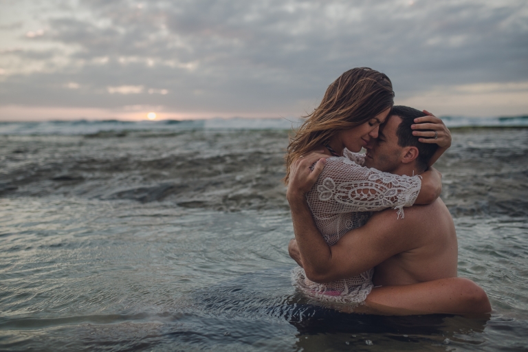 honeymoon couple embracing in the ocean in hawaii