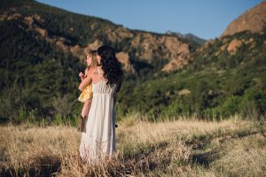 open field, yellow summer dress, cowboy boots, black wavy hair, boho style, rocky mountains, all heart workshop