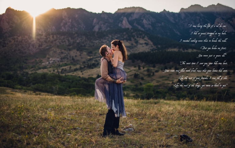 couple embraces at sunset in front of boulder mountains