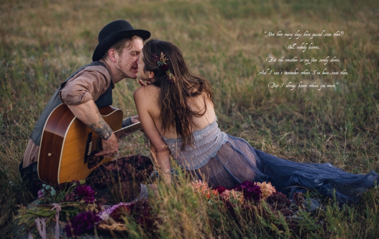 man holding guitar kissing woman wearing a blue free people dress during couples picnic