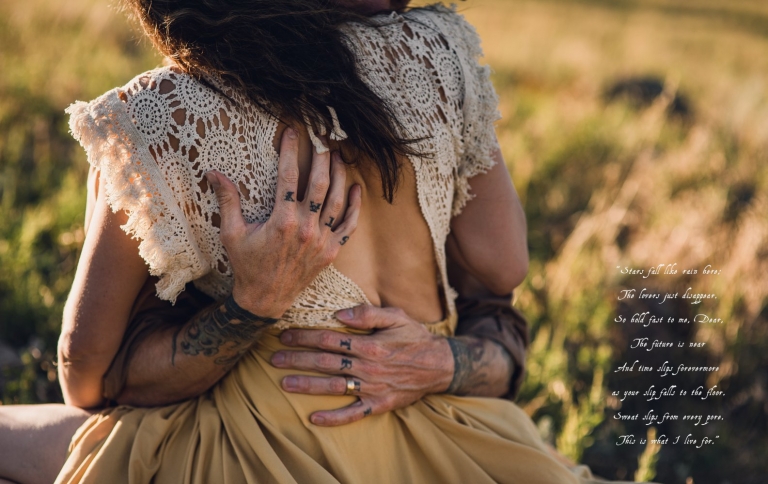 boulder couple sharing an intimate embrace in golden grass