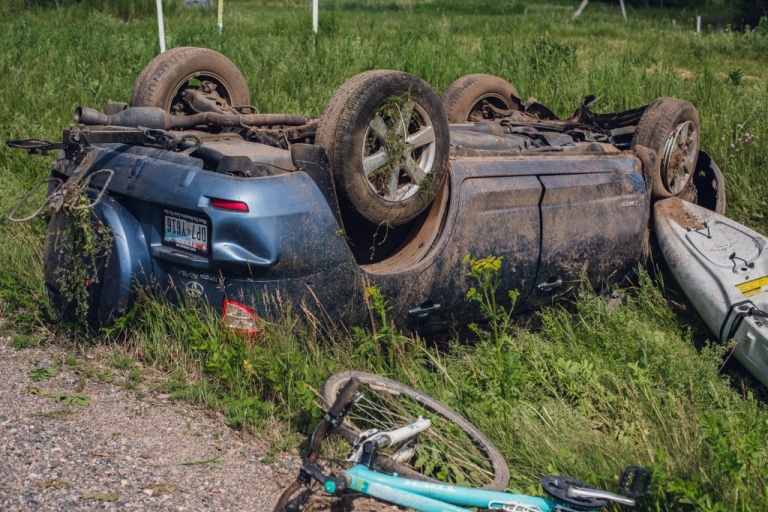 blue toyota rav4 accident upside down in a grassy ditch after hitting a deer